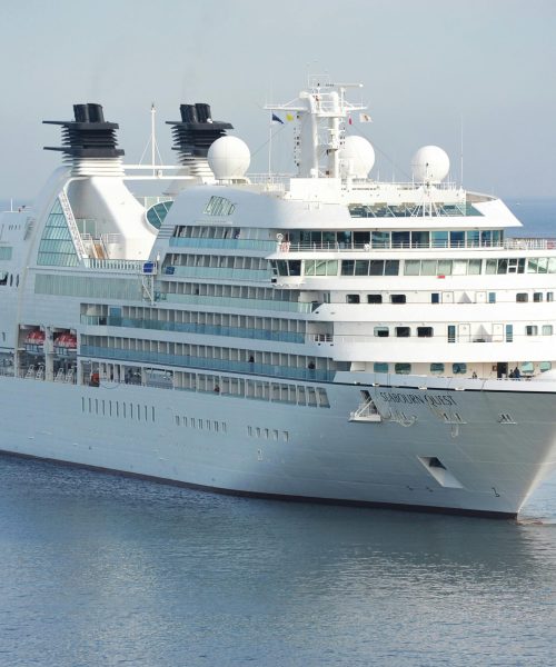 Elegant cruise ship sailing smoothly across tranquil waters under a clear sky.