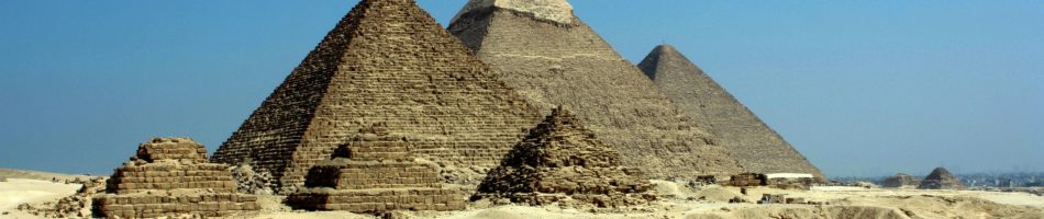 pexels photo 71241 71241 Capture of the iconic Pyramids of Giza under a clear blue sky with camels traversing the sandy desert.